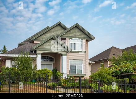 Außenansicht des Real Estate Front House an einem sonnigen Tag. Großes modernes maßgeschneidertes Luxushaus mit schön gestaltetem Vorgarten im Sommer. Wunderschönes Hausentr Stockfoto