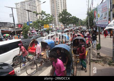 Dhaka, Bangladesch. August 27, 2023. Eine allgemeine Ansicht zeigt, dass Rikscha-Abzieher ihre Kunden in den Verkehr auf der New Market Road in DH transportieren Stockfoto