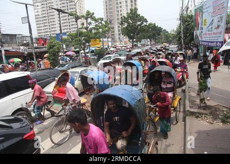 Dhaka, Bangladesch. August 27, 2023. Eine allgemeine Ansicht zeigt, dass Rikscha-Abzieher ihre Kunden in den Verkehr auf der New Market Road in DH transportieren Stockfoto