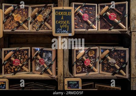 Menton, Frankreich - 26. Mai 2023: Große Schokoladentafel zum Brechen mit einem Hammer mit Obst und Nüssen in einem Kunsthandwerksladen in der Altstadt Stockfoto