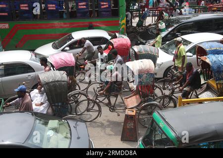 Dhaka, Bangladesch. August 27, 2023. Eine allgemeine Ansicht zeigt, dass Rikscha-Abzieher ihre Kunden in den Verkehr auf der New Market Road in DH transportieren Stockfoto