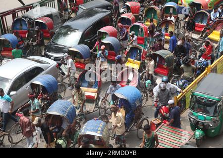 Dhaka, Bangladesch. August 27, 2023. Eine allgemeine Ansicht zeigt, dass Rikscha-Abzieher ihre Kunden in den Verkehr auf der New Market Road in DH transportieren Stockfoto