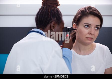 Otologiespezialarzt prüft auf Ohrenschmerzen, Trommelrupturen, Tinnitus und Ohrtaubheitssymptome. Arzt mit Otopolaryngologieinstrument in der Klinik während eines Arzttermins Stockfoto