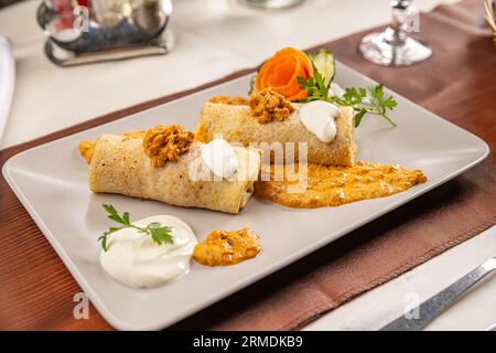 Pfannkuchen mit Fleisch und Eintopf auf dem Restauranttisch Stockfoto