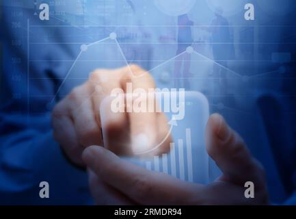 Mann mit futuristischem virtuellem Smartphone. Mobiles Aktienmarkt-, Handels-, Bank- und Geschäftskonzept. Stockfoto