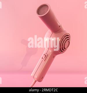Rosafarbener Haartrockner isoliert auf rosafarbenem Hintergrund 3D-Illustration Stockfoto