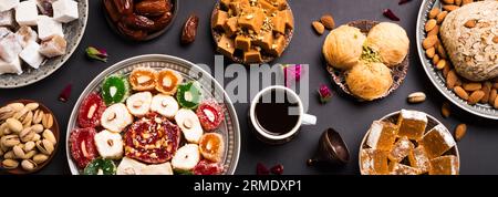 Nahöstliche Süßigkeiten, türkische Köstlichkeiten und schwarzer Kaffee auf schwarzem Hintergrund, Banner. Arabisches Dessertsortiment, rahat lokum, Halva, Sherber, Pismaniye Stockfoto