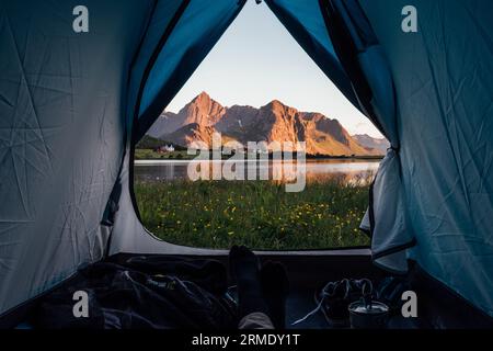 Mann, der sich auf einem Zelt mit wunderschöner Aussicht entspannt Stockfoto