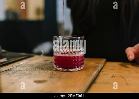 Die junge Barfrau bereitet einen alkoholischen Cocktail in der Bar zu. Konzentrieren Sie sich auf Getränke Stockfoto