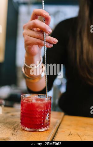 Die junge Barfrau bereitet einen alkoholischen Cocktail in der Bar zu. Stockfoto