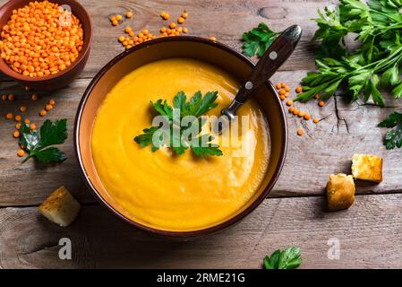 Rote Linsensuppe auf hölzernem Hintergrund aus nächster Nähe. Traditionelle Küche aus dem Nahen Osten, türkisch, ramadan. Veganes Essen. Stockfoto