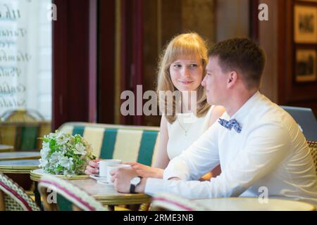 Wunderschönes, frisch verheiratetes Paar, das Kaffee in einem Pariser Café trank Stockfoto