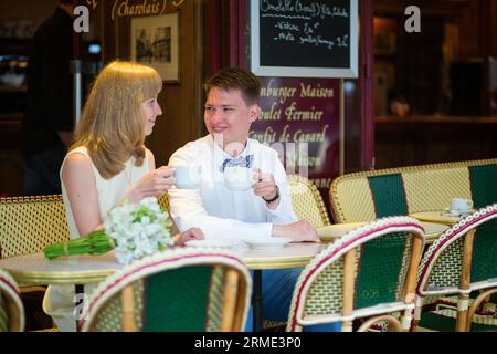 Wunderschönes, frisch verheiratetes Paar, das Kaffee in einem Pariser Café trank Stockfoto