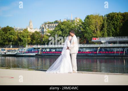 Wunderschönes, frisch verheiratetes Paar am seine-Ufer in Paris Stockfoto