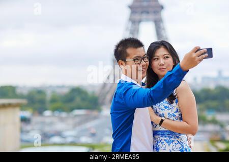 Wunderschöne asiatische Touristen verbringen ihren Urlaub in Paris und nehmen Selfie mit einem Handy mit dem Eiffelturm im Hintergrund Stockfoto