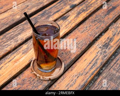 Schließen Sie ein Glas frischen Litschi-Tee auf einem alten Holztisch. Stockfoto