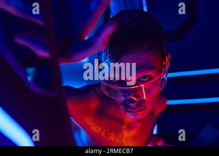 Extraterrestrisches Humanoid in Schutzbrillen, die aus dem Experimentalgerät im Discovery Center ausschauen Stockfoto