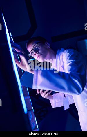 Futuristisches Konzept: Junge Praktikantin erforscht experimentelles Gerät im Innovationszentrum Stockfoto