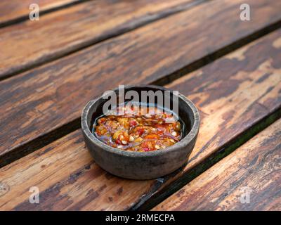 Sambal Bawang, scharfe Zwiebelsauce, traditionelle Chilisauce aus Indonesien, auf Holztisch. Stockfoto