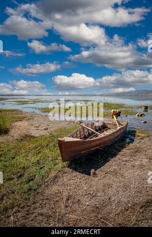 Verlassene Ruderboote auf gerissenen Böden auf dem Seenbett trockneten aufgrund der globalen Erwärmung und Dürre aus Stockfoto