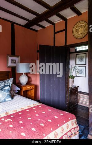 Kräftige Farben im Schlafzimmer des Tudor Farmhauses mit Fachwerkrahmen, Surrey, Großbritannien Stockfoto