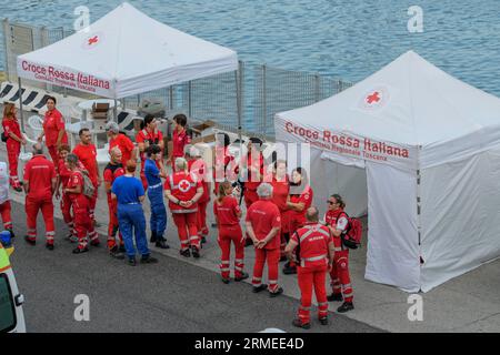 Livorno, Italien. 27. August 2023. Die Betreiber des Roten Kreuzes warten auf die Ankunft des Schiffs Humanity 1, das 57 vor der libyschen Küste gerettete Migranten im Hafen von Livorno befördert.das Schiff Humanity 1 der deutschen NRO United 4 Rescue und SOS Humanity, er musste mehr als 1.000 Kilometer zurücklegen, um den vom italienischen Innenministerium zugewiesenen sicheren Hafen zu erreichen. Seit dem Inkrafttreten des "NRO-Dekrets" sind die Ausschiffungshäfen von NRO-Schiffen zunehmend von den Rettungszonen entfernt. (Bild: © Marcello Valeri/ZUMA Press Wire) EDITORIAL Stockfoto