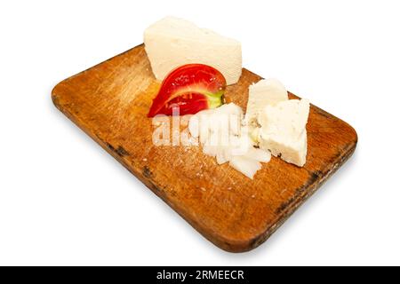 Ziegenkäse mit Tomaten und Zwiebelstückchen auf einem Holzbrett auf weißem Hintergrund Stockfoto