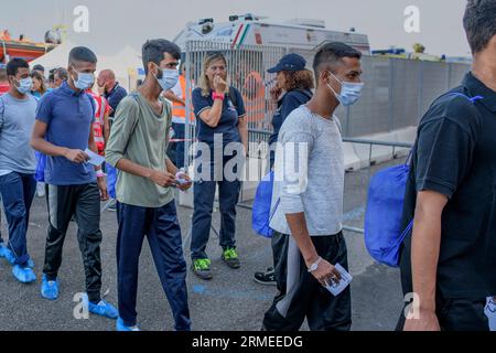 Livorno, Italien. 27. August 2023. Einige der 57 Migranten, die vor der libyschen Küste durch das Schiff Humanity 1 gerettet wurden, als sie die Landungskai des Hafens Livorno verlassen.das Schiff Humanity 1 der deutschen NGOs United 4 Rescue und SOS Humanity, er musste mehr als 1.000 Kilometer zurücklegen, um den vom italienischen Innenministerium zugewiesenen sicheren Hafen zu erreichen. Seit dem Inkrafttreten des "NRO-Dekrets" sind die Ausschiffungshäfen von NRO-Schiffen zunehmend von den Rettungszonen entfernt. (Bild: © Marcello Valeri/ZUMA Press Wire) NUR REDAKTIONELLE VERWENDUNG! Nicht f Stockfoto