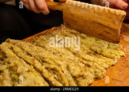 Gegrillte Auberginen oder Auberginen auf einem Schneidebrett mit traditionellem Beil aus Holz, weicher Nahfokus Stockfoto