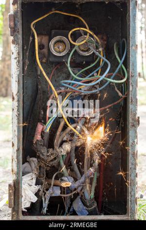 Klassischer Leistungsschalter mit schmutzigen Drähten, Funken und Flammen, Kurzschlusskonzept Stockfoto