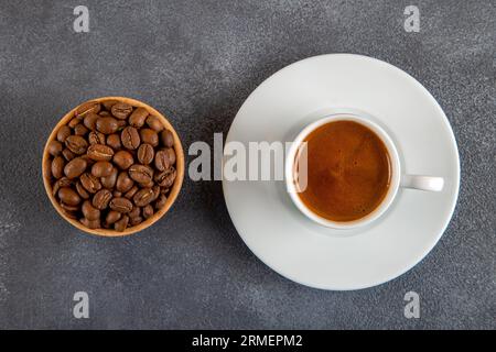 Geröstete Kaffeebohnen mit einer Tasse türkischem Kaffee auf dem schwarzen Betonboden Stockfoto