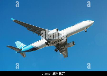 Kanadische Fluggesellschaft Air Transat mit Airbus A330, die am Flughafen Lissabon vor blauem Himmel landen wird Stockfoto