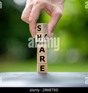 Ein Stapel Holzwürfel bilden die Worte Pflege und Teilen. Stockfoto