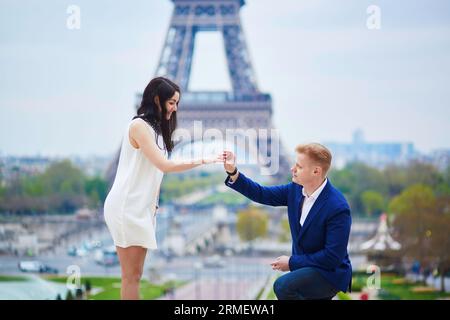 Romantische Verlobung in Paris, ein Mann, der seiner schönen Freundin nahe dem Eiffelturm einen Vorschlag machte. Überraschendes Angebot oder Konzept für eine Lösung Stockfoto