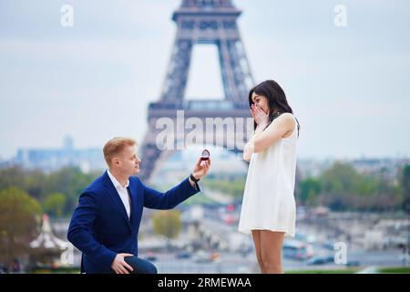 Romantische Verlobung in Paris, ein Mann, der seiner schönen Freundin nahe dem Eiffelturm einen Vorschlag machte. Überraschendes Angebot oder Konzept für eine Lösung Stockfoto