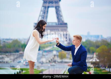 Romantische Verlobung in Paris, ein Mann, der seiner schönen Freundin nahe dem Eiffelturm einen Vorschlag machte. Überraschendes Angebot oder Konzept für eine Lösung Stockfoto