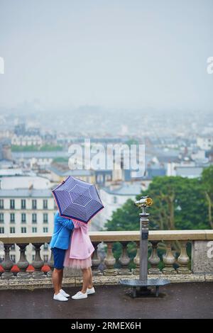 Romantisches Paar mit Sonnenschirm auf Montmartre an regnerischen Tagen in Paris, Frankreich Stockfoto