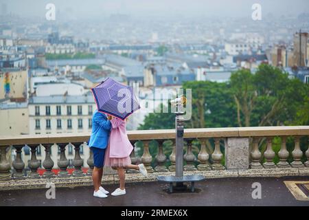 Romantisches Paar mit Sonnenschirm auf Montmartre an regnerischen Tagen in Paris, Frankreich Stockfoto