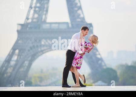 Wunderschönes romantisches Paar, das sich vor dem Eiffelturm in Paris, Frankreich, umarmt Stockfoto