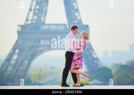 Wunderschönes romantisches Paar, das sich vor dem Eiffelturm in Paris, Frankreich, umarmt Stockfoto