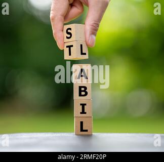 Ein Holzwürfelstapel bildet die deutschen Wörter „labil“ (instabil) und „stabil“ (stabil). Stockfoto