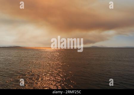 Rauch und Feuer auf den griechischen Inseln im Sommer vom Meer Stockfoto