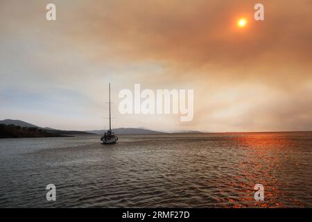 Rauch und Feuer auf den griechischen Inseln im Sommer vom Meer Stockfoto