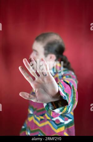 Hipster-Mann, der den Kopf bewegt und mit offener Hand „Nein“ oder „Stopp“ zur Kamera sagt Stockfoto