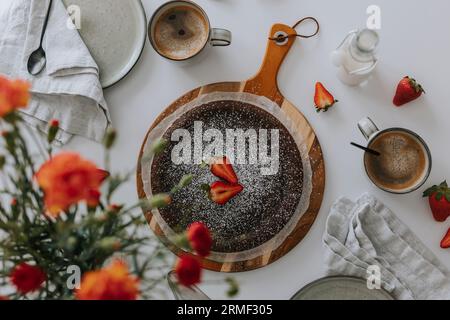 Frisch gebackener Schokoladenkuchen mit Erdbeeren auf dem Tisch Stockfoto