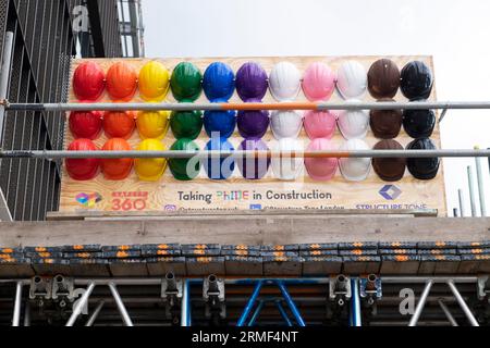 Farbenfrohe mehrfarbige Pride LGBT LGBTQ Construction Schutzhelme Schutzhelme von Uniqlo auf der Southbank Bankside in London, Großbritannien 2023 Stockfoto