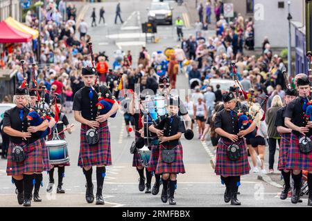 Eine schottische Pfeifenband, die vor den Scottish Coal Carry Championships durch die Straße marschiert, Kelty, Fife Stockfoto