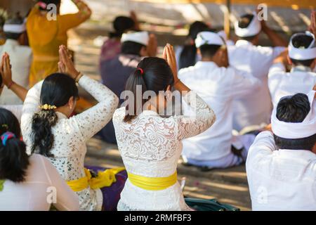 Junge balinesische Frauen beten in einem Tempel während der Zeremonie Stockfoto