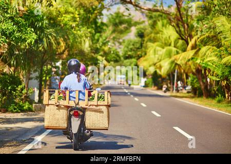 Balinesischer Mann mit großem Gepäck auf einem Roller Stockfoto