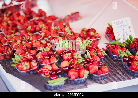 Frische Erdbeeren, grüne Erbsen und Blaubeeren zum Verkauf auf dem lokalen Lebensmittelmarkt in Helsinki, Finnland. Auf dem Etikett steht: Mix of Beeren (Übersetzung aus Finni Stockfoto